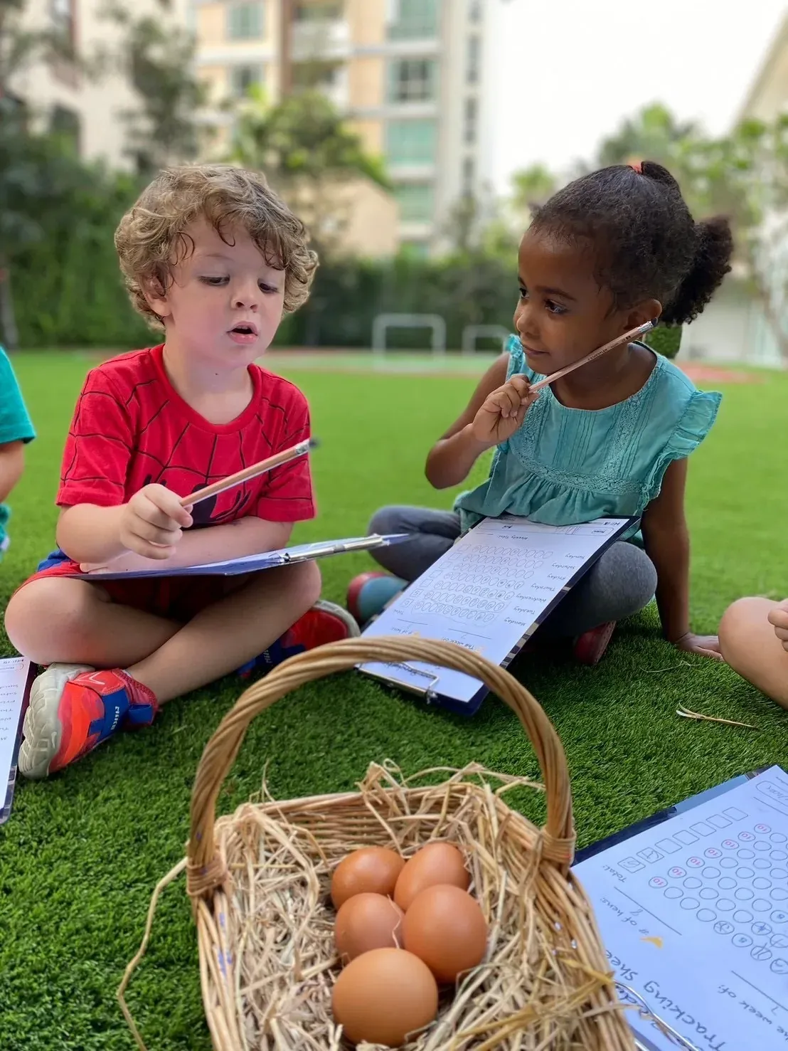 Two children recording the egg count on their tracking sheets
