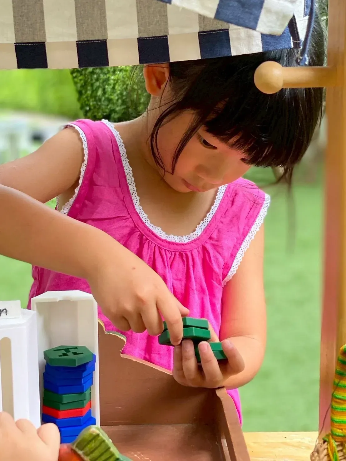 A girl behind the stall counting the KIMS coins she has taken
