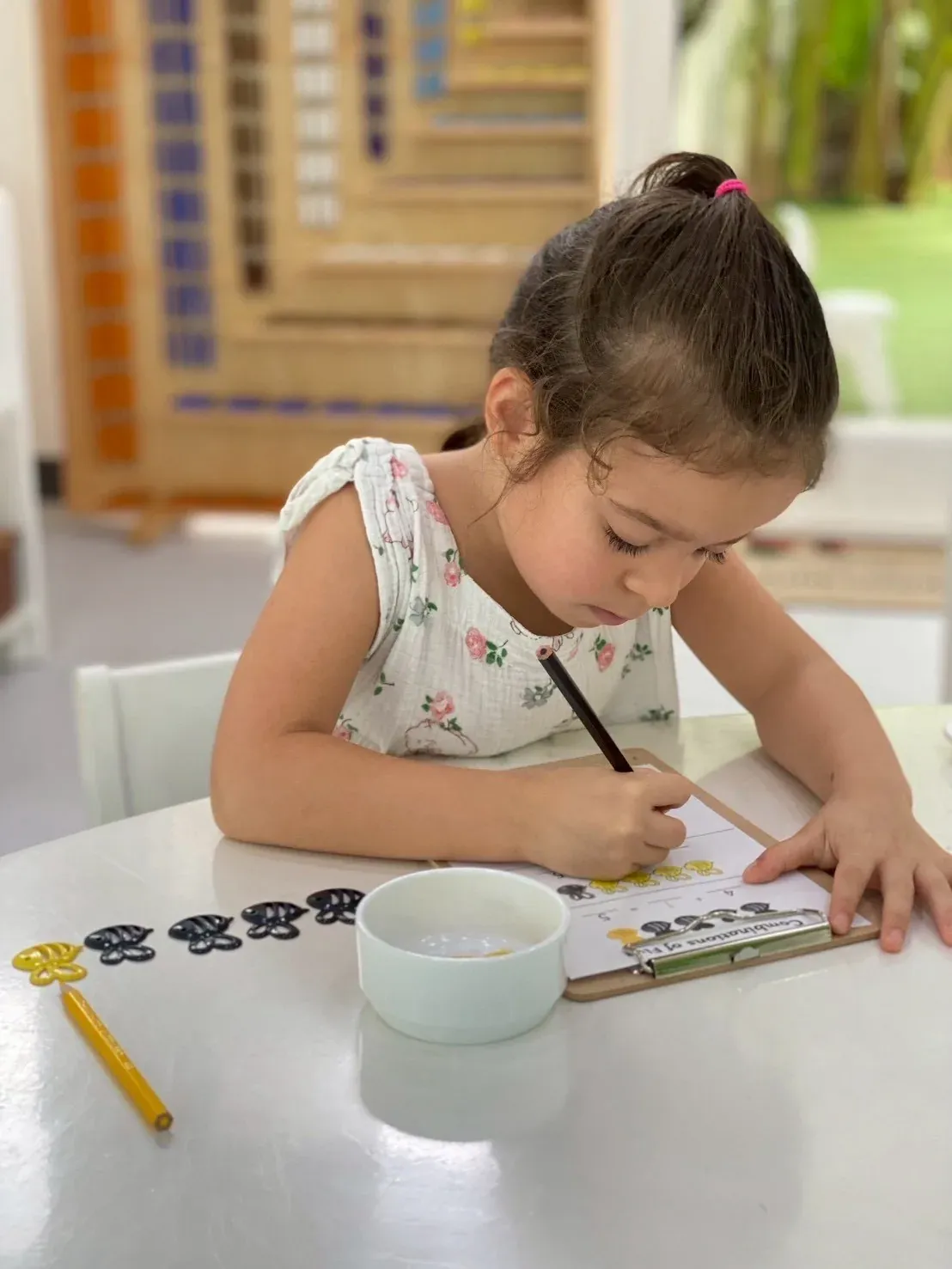Mathematics: a girl writing number combinations on a clipboard