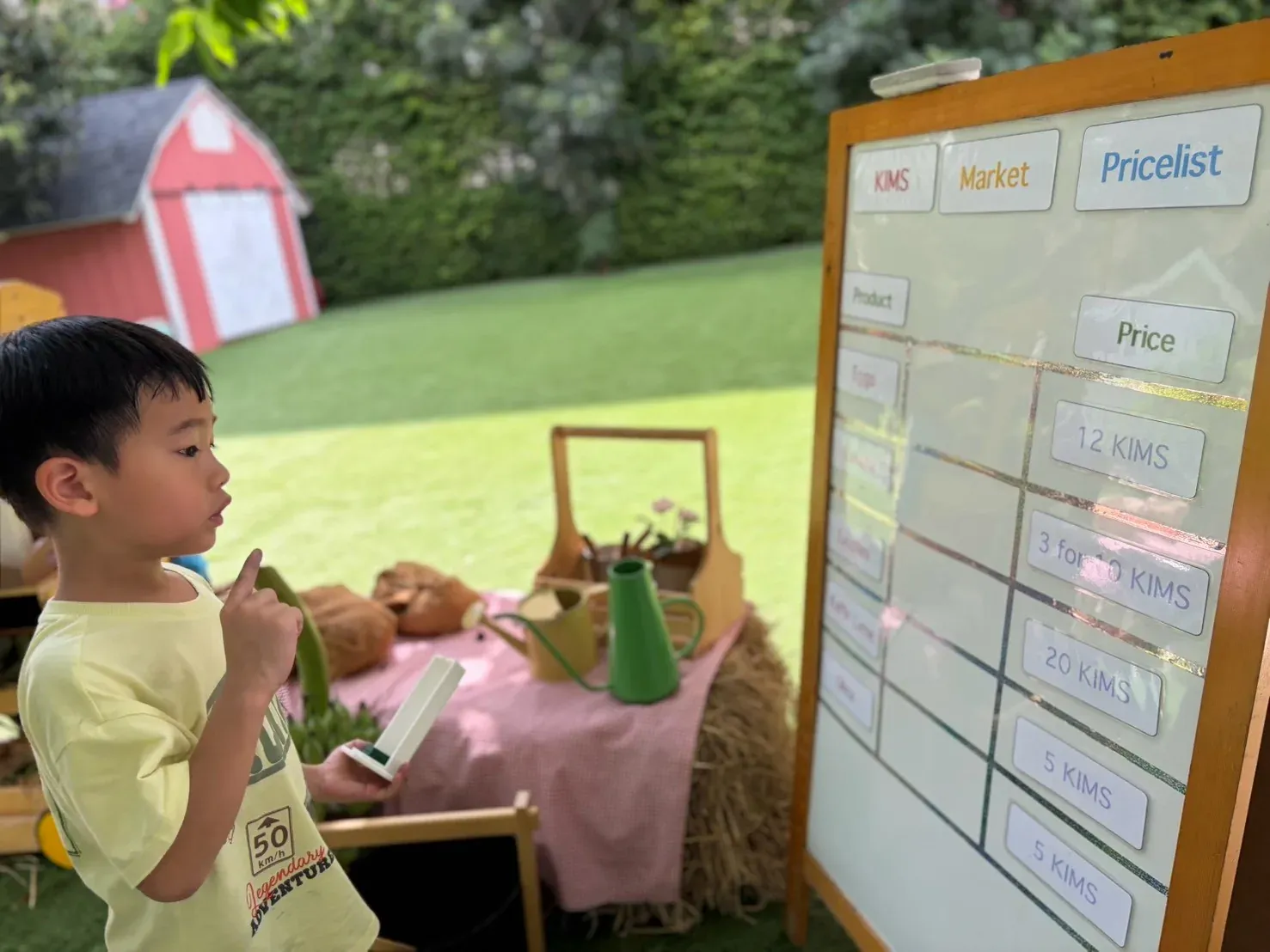 A boy reading the KIMS Market price list, deciding what his coins will buy