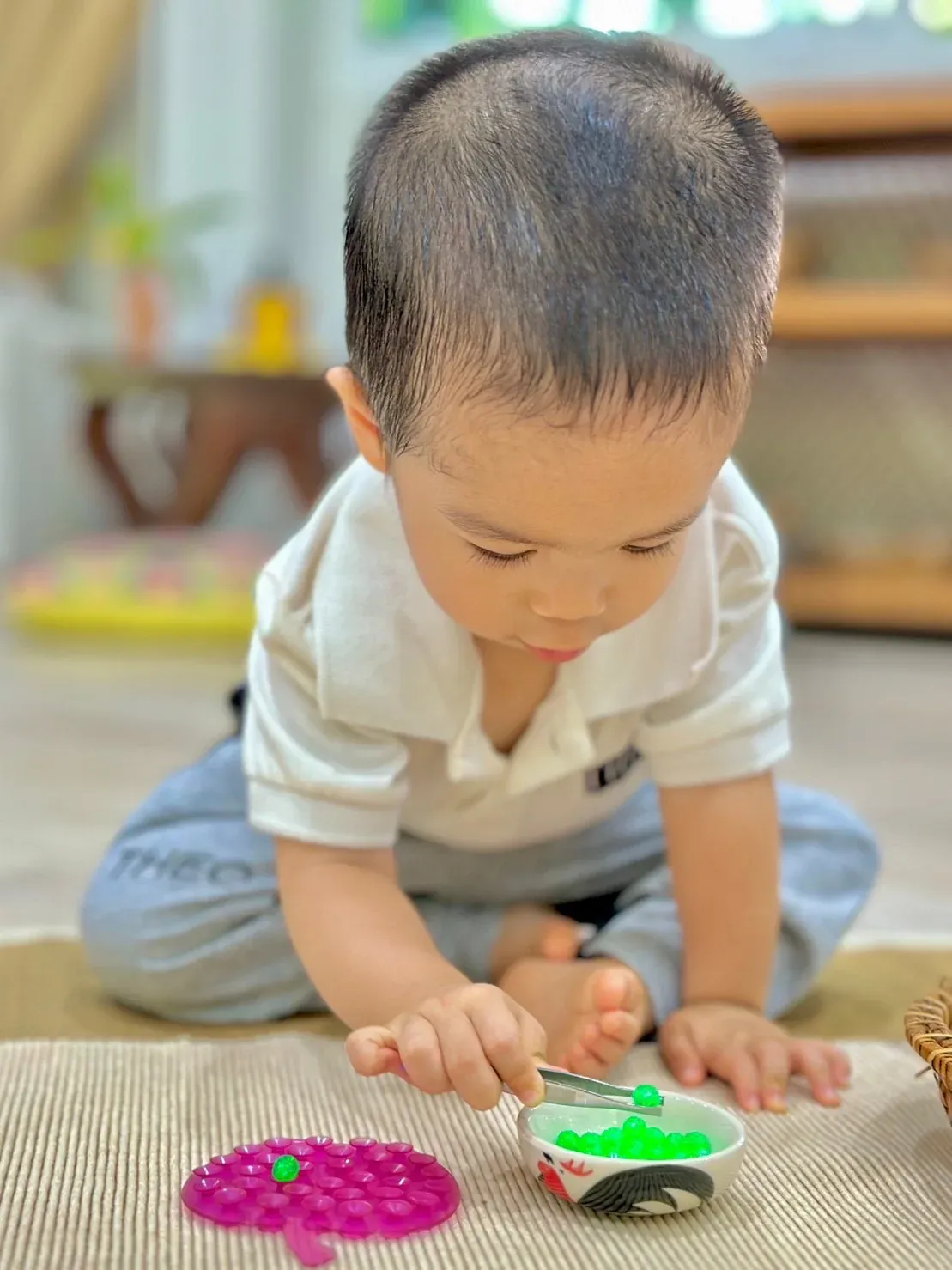 A child concentrating on a practical life Montessori exercise
