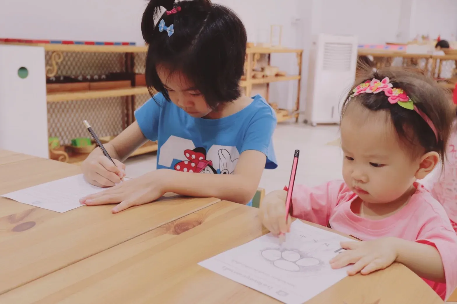 A teacher guiding one child through a Montessori activity