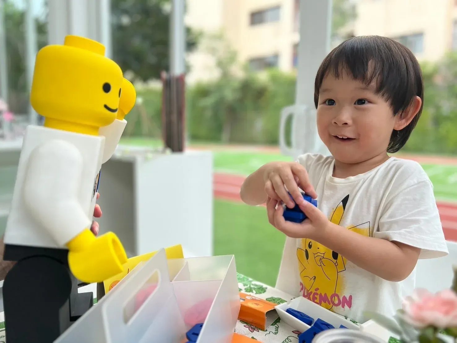 A boy pitching his goods to a buyer across the market table